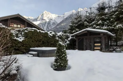 a snow covered yard with a house and a snow covered mountain at Balcon De l Europe - Jacuzzi prive - Vues in Les Houches