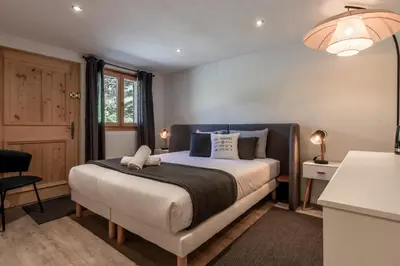 a bedroom with a bed and a desk and a chair at Balcon De l Europe - Jacuzzi prive - Vues in Les Houches