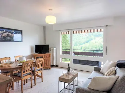 a living room with a couch and a table with wine glasses at Apartment La côte du Parc-1 by Interhome in Saint-Gervais-les-Bains