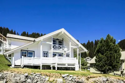 a white house on a hill with trees at Les Chalets de Flaine Hameau - maeva Home - Chalet 5 Pièces 10 Personnes - Exclusive MAE-0944 in Flaine