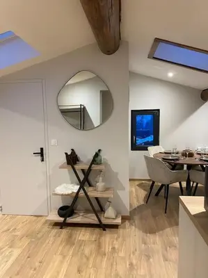 a dining room with a table and a mirror at Appartement Brévent in Les Houches