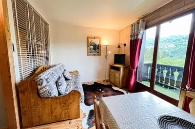 a living room with a couch and a window at Comfortable studio with pool and view in Saint-Gervais-les-Bains