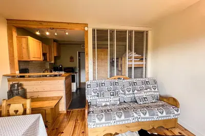 a living room with a couch and a kitchen at Comfortable studio with pool and view in Saint-Gervais-les-Bains