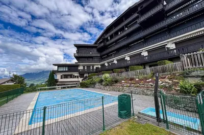 a building with a swimming pool in front of a building at Comfortable studio with pool and view in Saint-Gervais-les-Bains