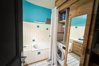a bathroom with a sink and a washing machine at Comfortable studio with pool and view in Saint-Gervais-les-Bains