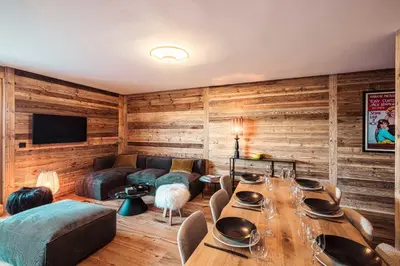 a living room with wooden walls and a table with chairs at Appartement Boréal - At the summit of Combloux in Combloux