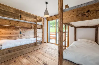two bunk beds in a room with wooden walls at Appartement Boréal - At the summit of Combloux in Combloux