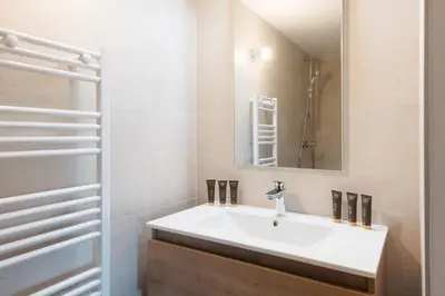 a bathroom with a white sink and a mirror at Appartement Boréal - At the summit of Combloux in Combloux