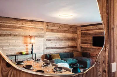 a room with a couch and a table with wine glasses at Appartement Boréal - At the summit of Combloux in Combloux
