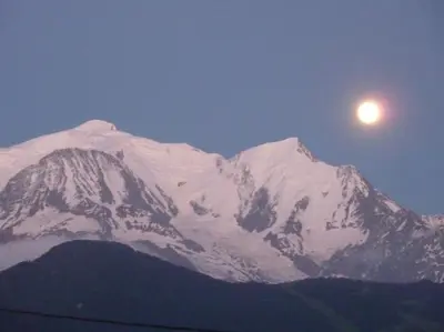 a snow covered mountain with the moon in the sky at Premier étage d'une ferme rénovée in Passy
