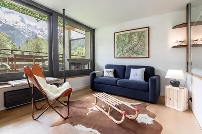 a living room with a blue couch and a chair at Lac des Gaillands - Renove - Balcon avec vues in Chamonix-Mont-Blanc