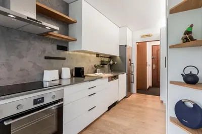 a kitchen with white cabinets and stainless steel appliances at Lac des Gaillands - Renove - Balcon avec vues in Chamonix-Mont-Blanc