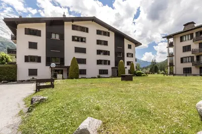 a large building with a grass field in front of it at Lac des Gaillands - Renove - Balcon avec vues in Chamonix-Mont-Blanc