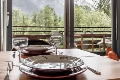 a table with glasses and plates on a table with a view at Lac des Gaillands - Renove - Balcon avec vues in Chamonix-Mont-Blanc