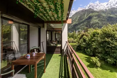 a dog sitting on a table on the porch of a house at Lac des Gaillands - Renove - Balcon avec vues in Chamonix-Mont-Blanc