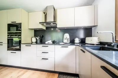 a kitchen with white cabinets and a sink at Apartment Lupin Megève - by EMERALD STAY in Megève