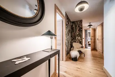 a room with a mirror and a table with a lamp at Apartment Lupin Megève - by EMERALD STAY in Megève