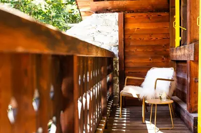 a wooden porch with a chair and a table at Three Bedroom Chalet Lemon Pit Chamonix in Chamonix-Mont-Blanc