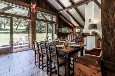 a dining room with a wooden table and chairs at La Poya haut - Calme - Vues magnifiques in Les Houches