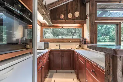 a kitchen with wooden cabinets and a window at La Poya haut - Calme - Vues magnifiques in Les Houches
