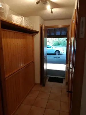 a hallway with a door and a car parked outside at SAMOENS appartement proche du centre in Samoëns