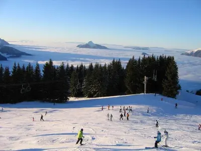 a group of people skiing down a snow covered slope at SAMOENS appartement proche du centre in Samoëns