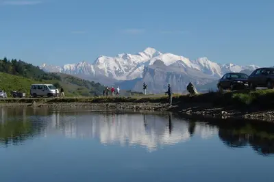 a body of water with snow capped mountains in the background at SAMOENS appartement proche du centre in Samoëns