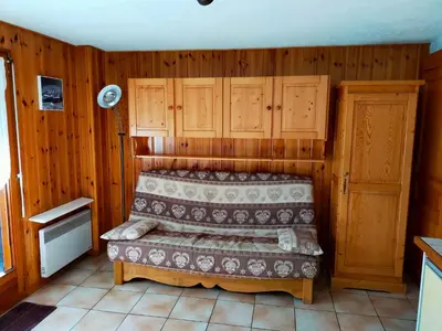 two beds in a room with wooden walls at SAMOENS appartement proche du centre in Samoëns