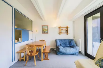 a dining room with a table and a blue chair at Résidence Aldébaran - maeva Home - Appartement 2 Pièces 6 Personnes - Confort MAE-3790 in Arâches-la-Frasse
