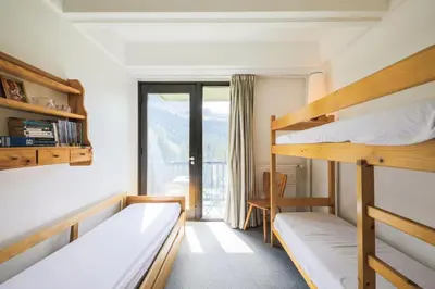 a room with two bunk beds and a balcony at Résidence Aldébaran - maeva Home - Appartement 2 Pièces 6 Personnes - Confort MAE-3790 in Arâches-la-Frasse