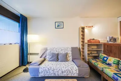 a living room with a bed and a couch at Résidence Gémeaux - maeva Home - Appartement 2 Pièces 6 Personnes - Confort MAE-3874 in Arâches-la-Frasse