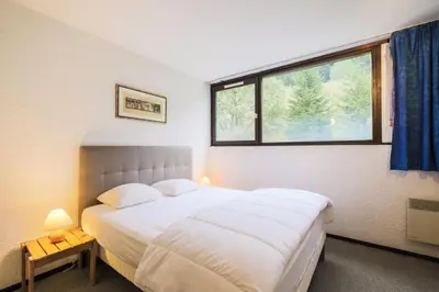 a bedroom with a large bed and a window at Résidence Gémeaux - maeva Home - Appartement 2 Pièces 6 Personnes - Confort MAE-3874 in Arâches-la-Frasse