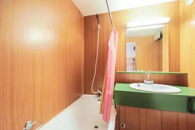 a bathroom with a sink and a tub and a mirror at Résidence Gémeaux - maeva Home - Appartement 2 Pièces 6 Personnes - Confort MAE-3874 in Arâches-la-Frasse