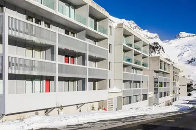 a building in the snow with a mountain in the background at Résidence La Petite Ourse - maeva Home - Appartement 3 Pièces 8 Personnes - Confort MAE-3901 in Arâches-la-Frasse