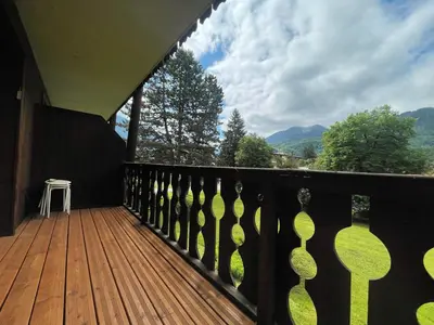 a balcony with a wooden deck with a stool on it at Studio rénové proche centre Samoëns avec balcon et proximité ski-bus - FR-1-624-159 in Samoëns