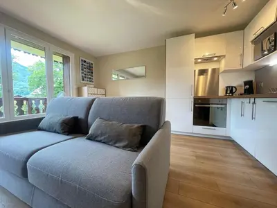 a living room with a couch and a kitchen at Studio rénové proche centre Samoëns avec balcon et proximité ski-bus - FR-1-624-159 in Samoëns