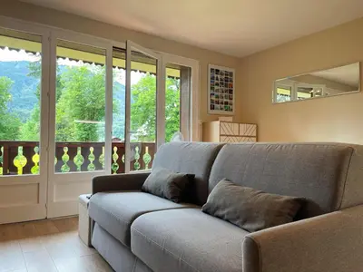 a living room with a couch and a balcony at Studio rénové proche centre Samoëns avec balcon et proximité ski-bus - FR-1-624-159 in Samoëns