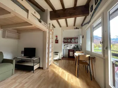 a living room with a loft bed and a kitchen at Studio cocooning à Samoëns avec balcon et WiFi au centre - FR-1-624-160 in Samoëns