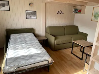 a small room with a bed and a couch at Studio cocooning à Samoëns avec balcon et WiFi au centre - FR-1-624-160 in Samoëns