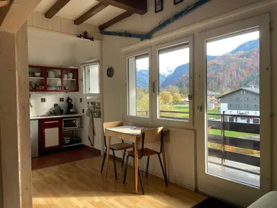 a kitchen with a table and a view of a mountain at Studio cocooning à Samoëns avec balcon et WiFi au centre - FR-1-624-160 in Samoëns
