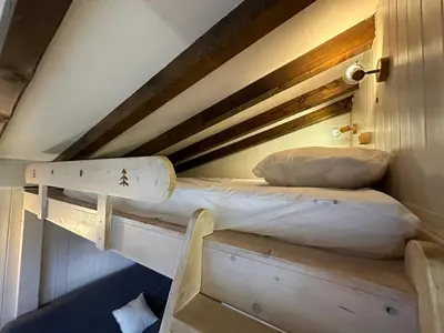 a bunk bed in a room with a wooden ceiling at Studio cocooning à Samoëns avec balcon et WiFi au centre - FR-1-624-160 in Samoëns