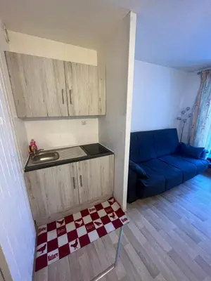 a living room with a blue couch and a sink at Aiguille 2 in Chamonix-Mont-Blanc