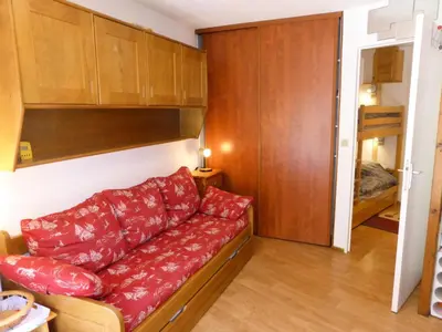 a living room with a red couch and a bedroom at Résidence Pierres Blanches - Pierres Blanches F392 MAE-9901 in Les Contamines-Montjoie