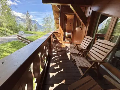 a porch of a house with wooden chairs on it at Appartement 3 Pièces + Mezzanine, 7 couchages, vue Mont-Blanc, Parking - FR-1-597-177 in Combloux