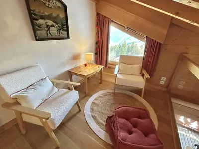 a living room with a chair and a table at Appartement 3 Pièces + Mezzanine, 7 couchages, vue Mont-Blanc, Parking - FR-1-597-177 in Combloux