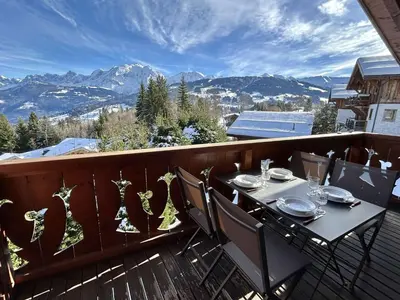 a table and chairs on a balcony with mountains at Appartement 3 Pièces + Mezzanine, 7 couchages, vue Mont-Blanc, Parking - FR-1-597-177 in Combloux