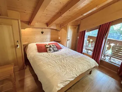 a bedroom with a bed in a log cabin at Appartement 3 Pièces + Mezzanine, 7 couchages, vue Mont-Blanc, Parking - FR-1-597-177 in Combloux