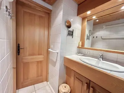a bathroom with a sink and a wooden door at Appartement 3 Pièces + Mezzanine, 7 couchages, vue Mont-Blanc, Parking - FR-1-597-177 in Combloux