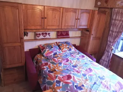 a bed in a room with wooden cabinets at Studio cabine pour 4 pers, animaux acceptés, internet, vue montagne - FR-1-629-136 in Samoëns