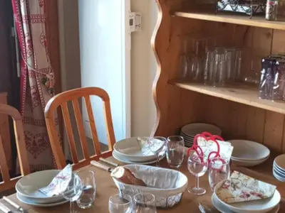 a wooden table with plates and glasses on it at Studio cabine pour 4 pers, animaux acceptés, internet, vue montagne - FR-1-629-136 in Samoëns